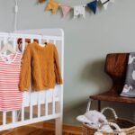 Berceau avec vêtements, panier de jouets, chaise avec couverture, bannières colorées